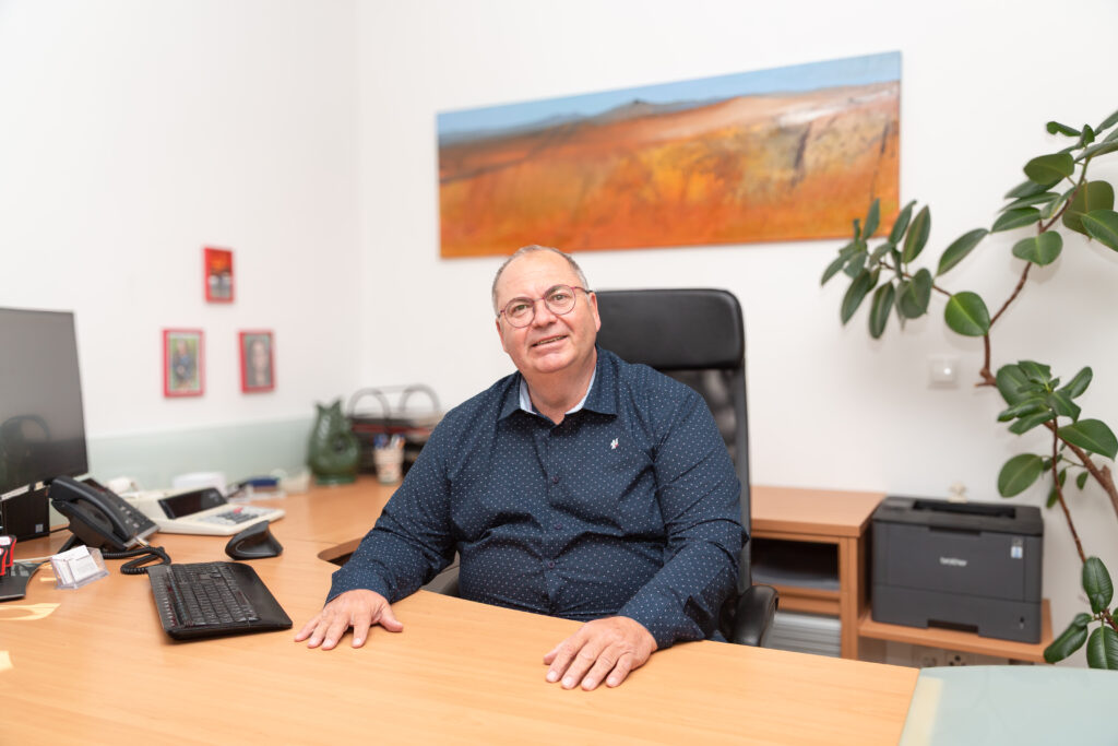 Auf diesem Bild sieht man Mag. Walter Gusel, Steuerberater aus Graz und Graz & Umgebung. Er lächelt leicht in die Kamera und sitzt an seinem Arbeitstisch.