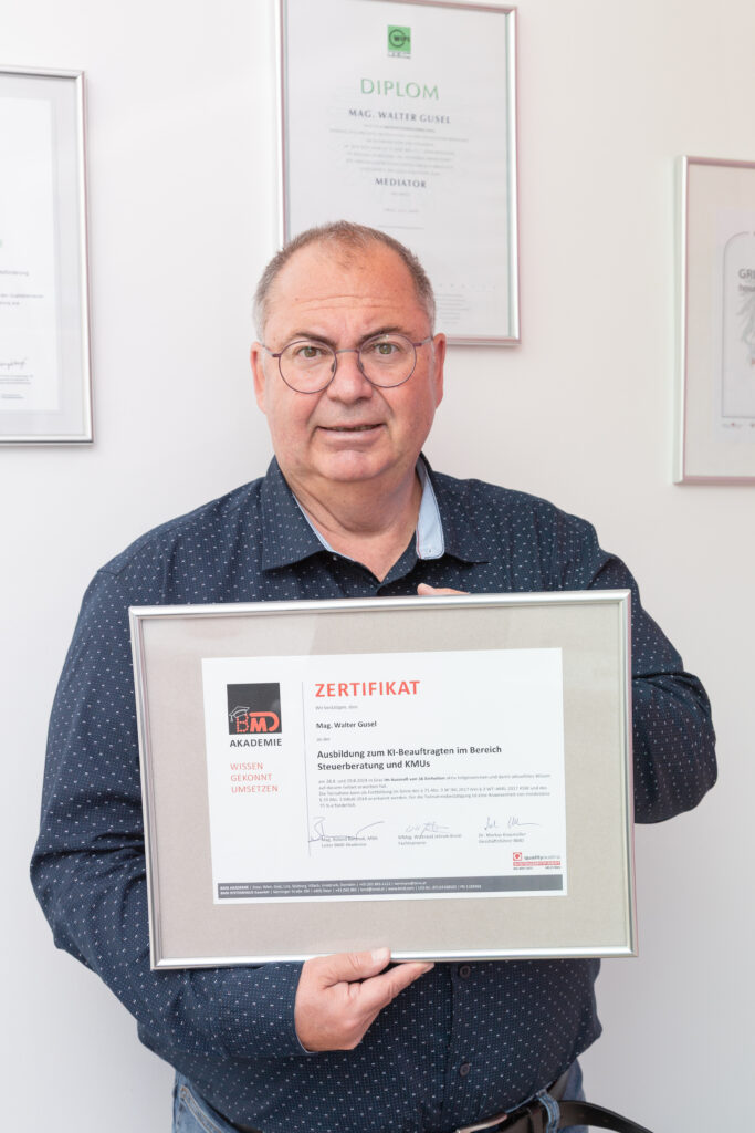 Steuerberater Mag. Walter Gusel. steht mit Zertifikat zum IT-Beauftragten vor einer Wand mit weiteren Auszeichnungen und Zertifikaten im Hintergrund.