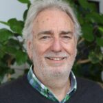 Lächelnder Klient blickt in freundlicher Atmosphäre in die Kamera – Symbol für positive Klientenmeinung und Zufriedenheit.